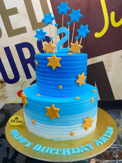 A 3kg two-tiered cake in a blue ombre design, decorated with simple yellow stars.