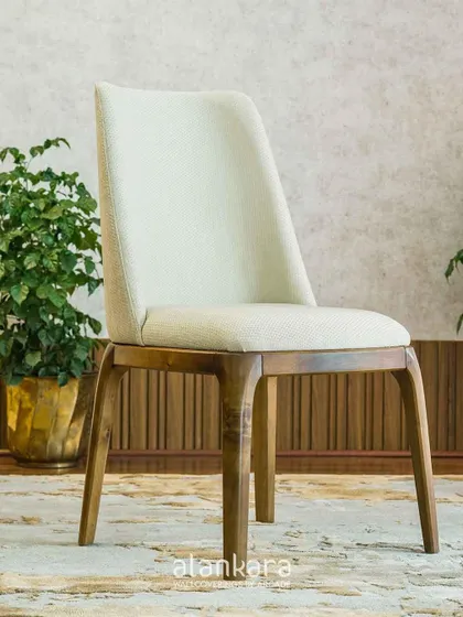 The 'White Arber' dining chair, featuring a simple, elegant design with a fully upholstered seat and back on a solid wood frame. It offers exceptional comfort for long, leisurely meals.