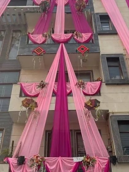 A stylish house decoration with pink drapes and hanging umbrellas. The clean and elegant design is perfect for a modern home.