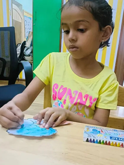 A young girl carefully coloring her artwork, a moment of quiet focus.
