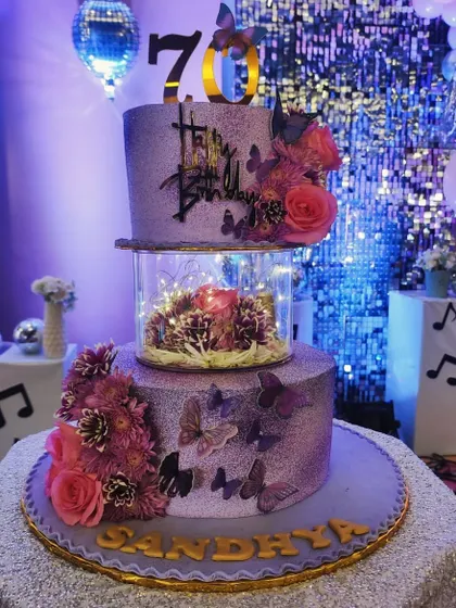 This magical floating cake was designed for a glamorous 70th birthday. The separator tier is filled with fairy lights and flowers, creating an enchanting illusion that makes the top tier appear to float.