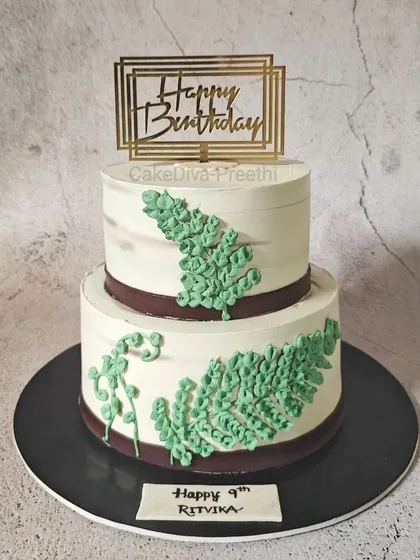 This minimalistic two-tier cake was for an eco-friendly themed birthday. It's a chocolate truffle cake with zero fondant, decorated with simple piped ferns for a natural and clean look.