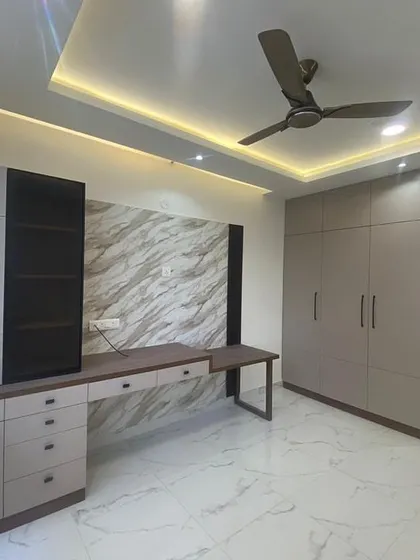 A full view of the bedroom with its integrated study desk and wardrobe. The neutral color palette creates a calm and sophisticated atmosphere.