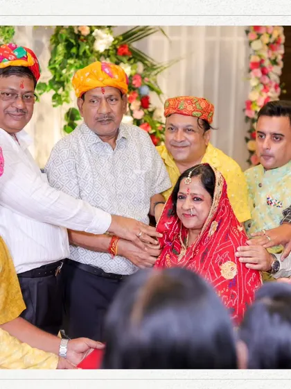 A group of men placing their hands on a woman's head in a gesture of blessing during a traditional ceremony.