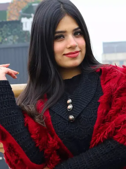 A close-up portrait from the winter series. This shot highlights the model's confident expression and the stylish details of her outfit, like the buttoned collar and cozy red wrap.