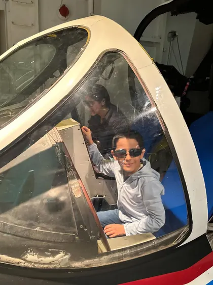 My son looking out from the cockpit of a plane. Museum visits are a huge part of our family's learning journey, offering incredible opportunities to explore history, science, and technology firsthand.