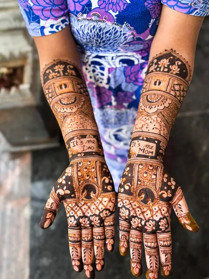 A lovely design for a naming ceremony, with "It's me Dad" and "It's me Mom" written on the arms, along with baby footprints and other cute motifs.