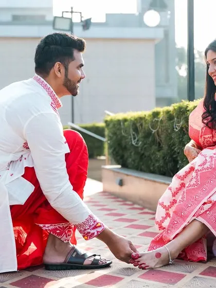 A sweet gesture as the groom helps the bride with her footwear.