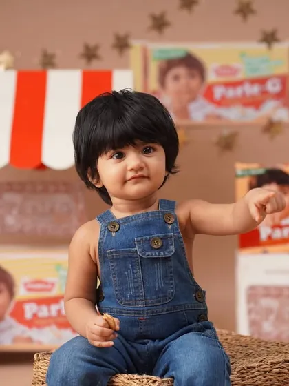 An identical shot showing the baby girl pointing, offering a slight variation in pose for the Parle-G themed gallery.