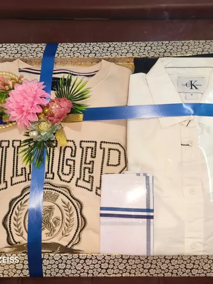 Another example of packing branded apparel, this time a Hilfiger sweatshirt and a Calvin Klein shirt. The blue ribbon and floral decor give it a premium gift feel.