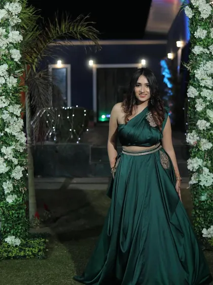 A poised, full-length shot of the green gown. This provides a clear and elegant view of the entire outfit for potential buyers.