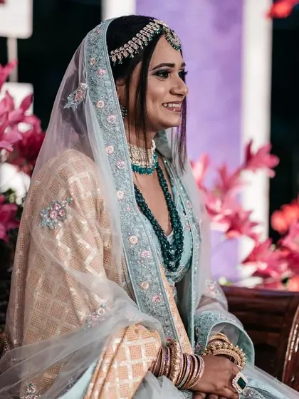 The bride looking elegant at her pre-wedding function. The decor features bright pink florals that complement her beautiful attire.