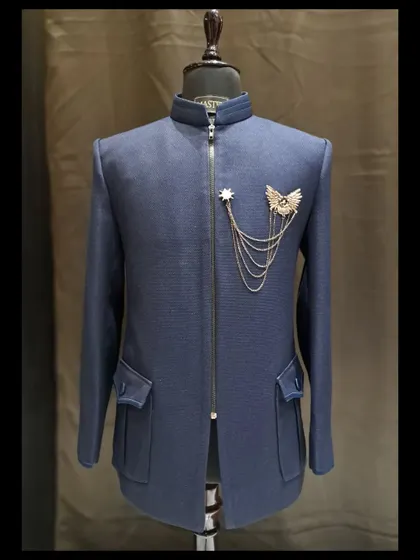 The final sketch of this indigo blue bandhgala became this stunning reality. It features a textured fabric, front zipper, and a custom metal brooch with a chain for a touch of military-inspired flair.