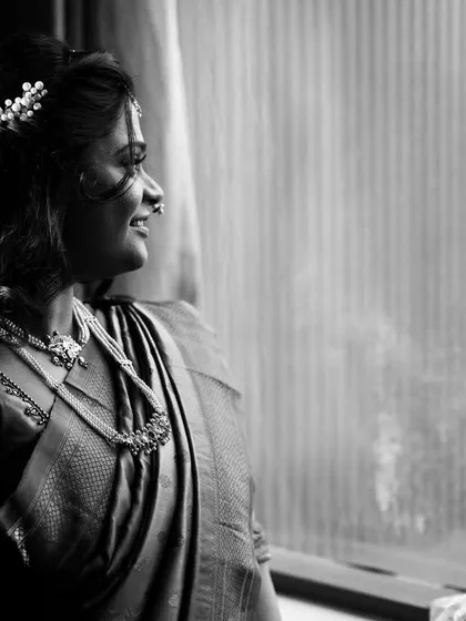 A black and white portrait of the bride looking out the window, lost in thought. A timeless and emotional getting-ready shot.