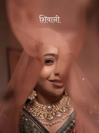A playful and intimate close-up of the bride, peeking through her veil with a smile. This shot captures her personality and the joy of the moment.