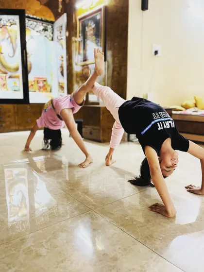 My students work together to create partner poses like this supported backbend. These exercises build trust, teamwork, and balance in our kids' yoga and flexibility classes.
