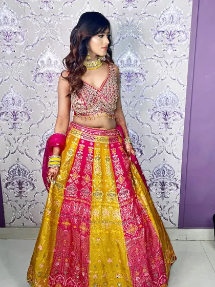 The full lehenga in vibrant pink and yellow. The makeup is kept soft and neutral to let the outfit be the star.