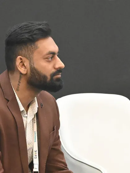 A candid shot of me listening intently during a panel discussion. It's crucial to be present and engaged with the content to guide the conversation effectively.