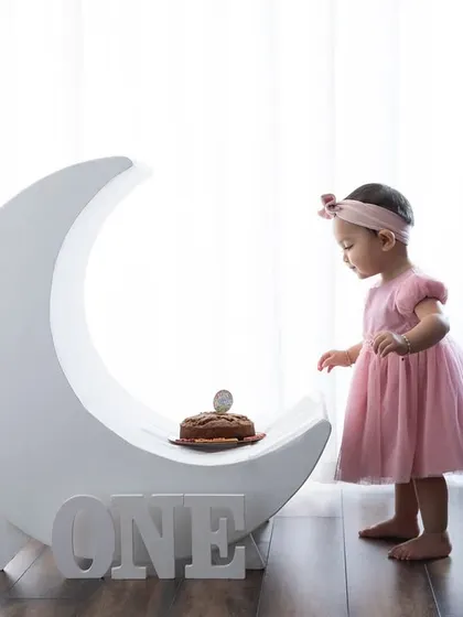 Over the moon for her first birthday! This simple and elegant moon prop with a tiny cake is a dreamy setup for a one-year-old.