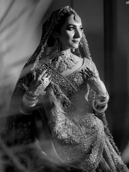 A timeless black and white portrait of the bride. The soft, diffused light and her elegant pose create a classic and sophisticated image.