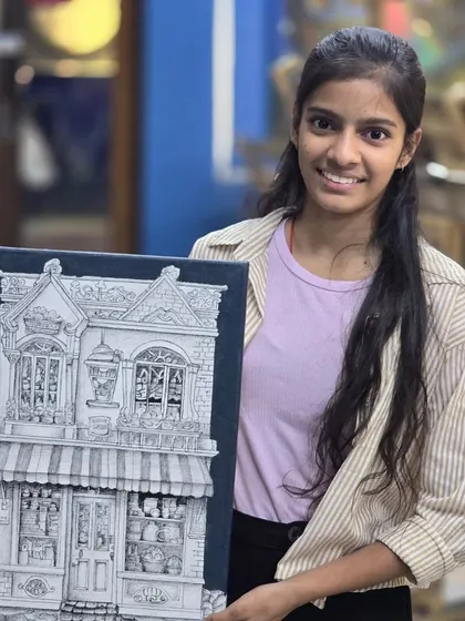 A proud student showcasing her intricate architectural drawing. Created with a micron pen on canvas, this piece highlights the precision and patience we teach in our technical drawing and illustration programs.