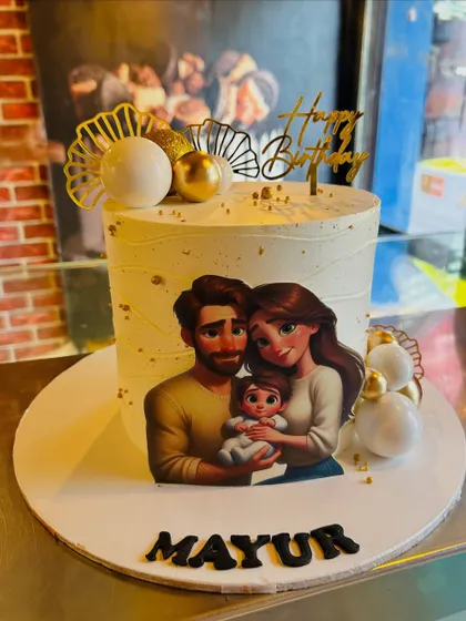A lovely family portrait cake, featuring an edible image of a couple with their baby, decorated with elegant gold and white spheres.