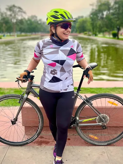 A female cyclist smiling by the water. Our club has a strong and growing community of women cyclists.