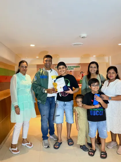 A group of proud families celebrating their children's success at the Abacus prize distribution program.