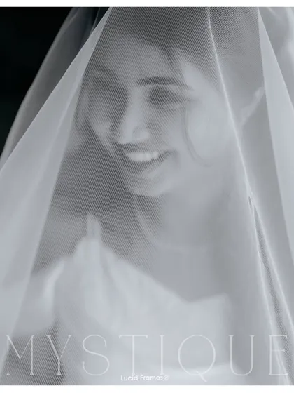 "Mystique." A smiling bride behind her veil, a classic and timeless black and white bridal portrait.