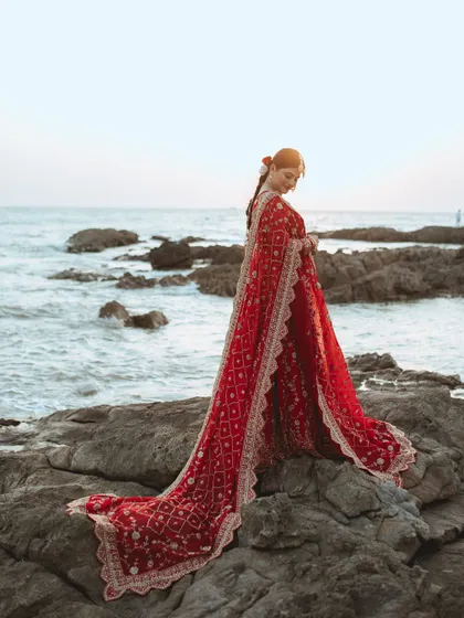We believe every bride deserves a portrait that feels like a piece of art. Here, we used the dramatic backdrop of the sea and the flowing red lehenga to create a timeless, powerful image of Alifa on her big day.