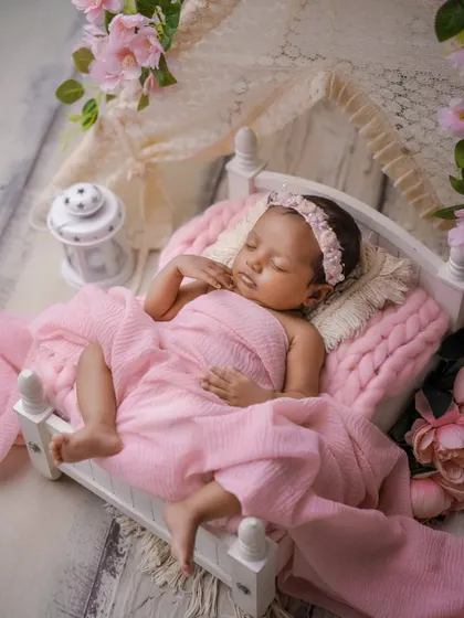 A sleeping beauty's rest. This baby is so peaceful in her pink floral bed, a perfect little princess.