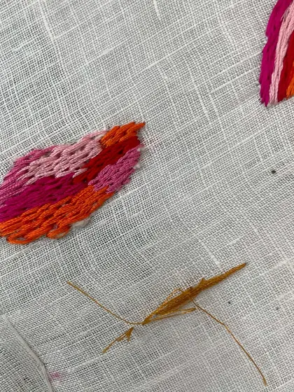 A close-up of the "Gauri Series" in progress. This shows the beginning of a lotus petal, with each stitch carefully placed to create a gradient of color. This is the slow, meditative process of embroidery.