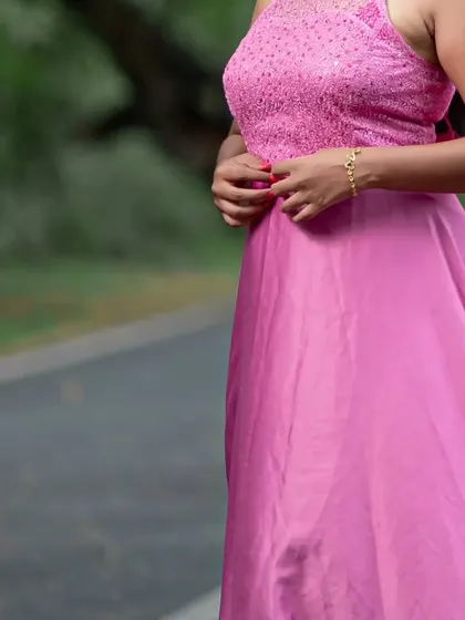 A detailed look at the textured bodice and delicate bracelet that complements this pink maternity photoshoot dress.