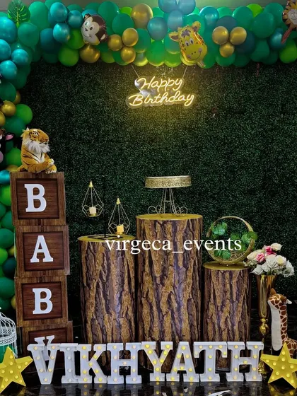 A rustic jungle-themed birthday with wood-textured pedestals and a green grass backdrop. The plush animal toys add a cute and interactive element.