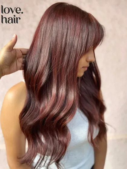 Living our Dua Lipa dreams with this cherry-cola look. We created this trending colour on long hair with a cute fringe for a result that's pure pop star.