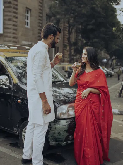 In the heart of South Bombay, we paused for a moment of quiet connection over cutting chai, with a classic kaali-peeli taxi framing this authentic, old-school romantic portrait.