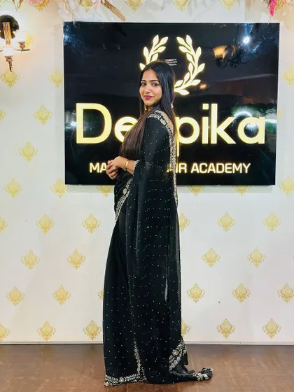 A side profile in the black saree, showing the simple yet elegant styling. This is a timeless look for any formal occasion.