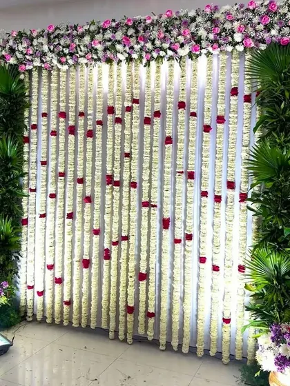 A beautiful wall of jasmine and rose garlands for a Seemantham ceremony. This simple yet stunning backdrop is perfect for photos and adds a traditional touch to the event.