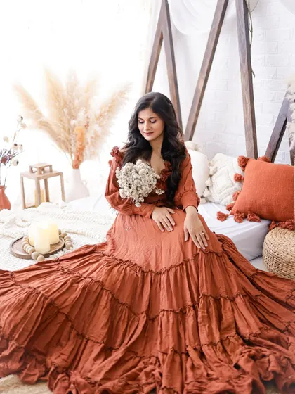 A beautiful portrait of a mom-to-be in a rustic, boho-chic setting. Her long, flowing dress and the natural decor create a warm and serene image.