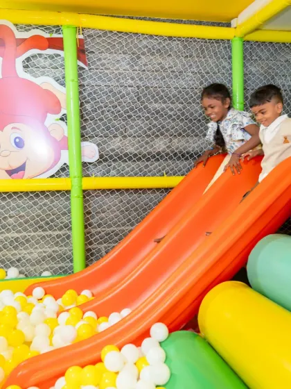 Two friends share a happy moment on the slide. Cooperative play like this is essential for building social skills, and our play equipment is designed to encourage these positive interactions.