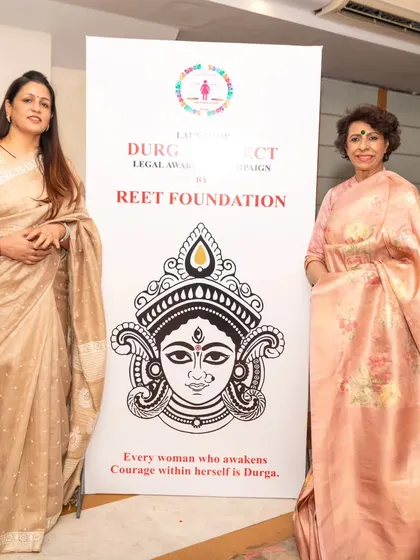 Standing beside a banner for my Reet Foundation's Project Durga with Ms. Renu Bhatia. The tagline says it all: "Every woman who awakens courage within herself is Durga."