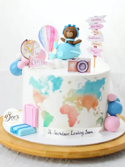 A travel-themed baby shower cake for a little adventurer on the way. It features a hand-painted world map, a fondant airplane, and signs pointing to famous cities.