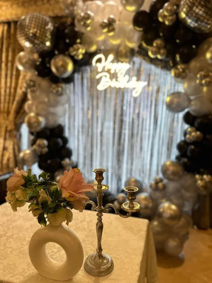 A detail shot of the birthday cake table, with our balloon and tinsel backdrop creating a festive and sparkling background.