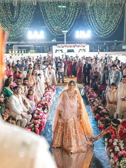 The bride's entrance is one of the most awaited moments. I designed this aisle with a reflective surface and lined it with a garden of flowers, making her walk towards the groom feel truly magical.