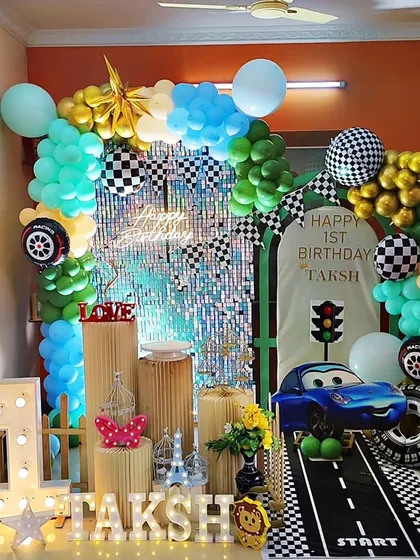 Another high-speed car-themed birthday, this one for Taksh's first birthday. It features a race track entrance, checkered flag details, and a shiny sequin backdrop for extra excitement.