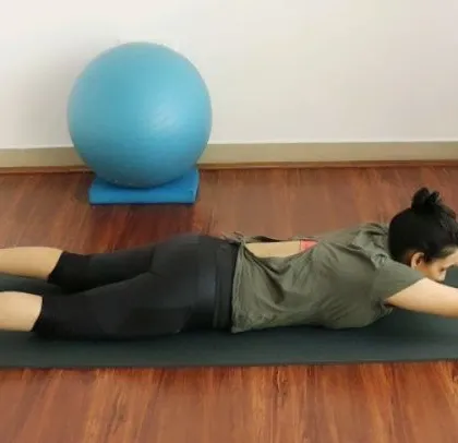 A client demonstrates the "Super Mom" pose, a fantastic exercise for strengthening the entire back of the body.