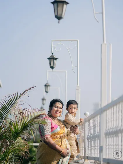 A sweet family portrait of a mother-to-be holding her young son on a balcony during her baby shower celebration.