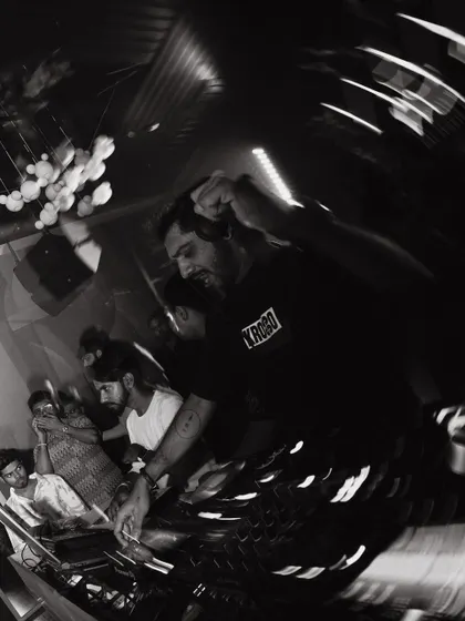 An artistic, motion-blur shot that captures the chaotic energy and movement of a live DJ set.