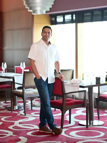 A confident pose in a restaurant setting. This type of lifestyle shot helps potential matches envision a life together and shows a sophisticated side.