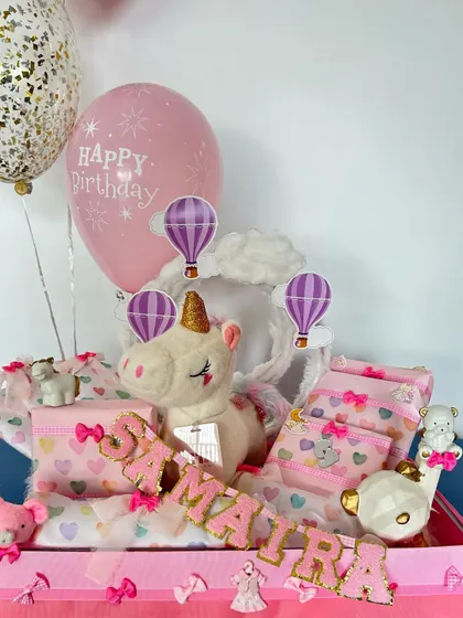 Another view of the unicorn hamper, highlighting the personalized name in glittery letters and a 'Happy Birthday' balloon.
